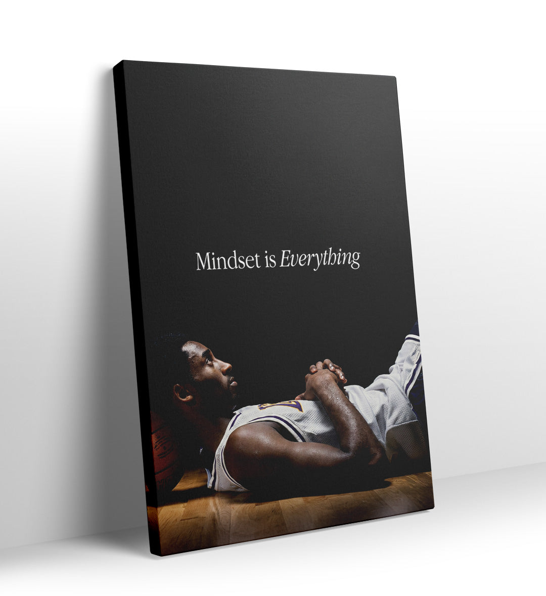 Kobe Bryant lying on the floor resting his head on a basketball with "Mindset is Everything" text canvas wall art.
