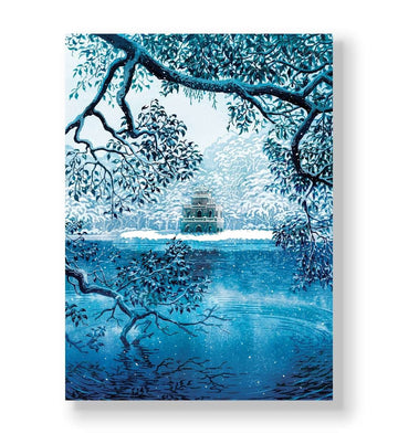 Pagoda on an island in a frozen blue lake framed by snowy branches canvas wall art.